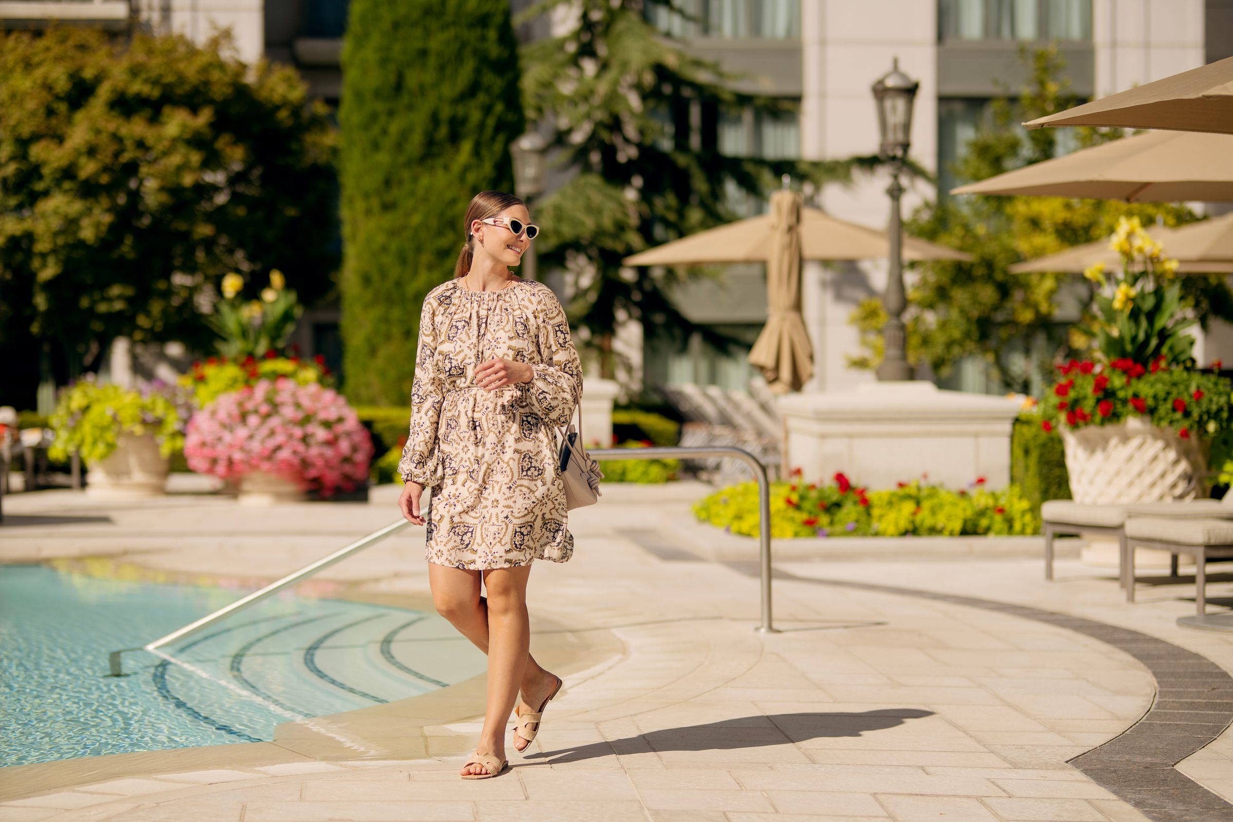 Woman walking in front of outdoor pool