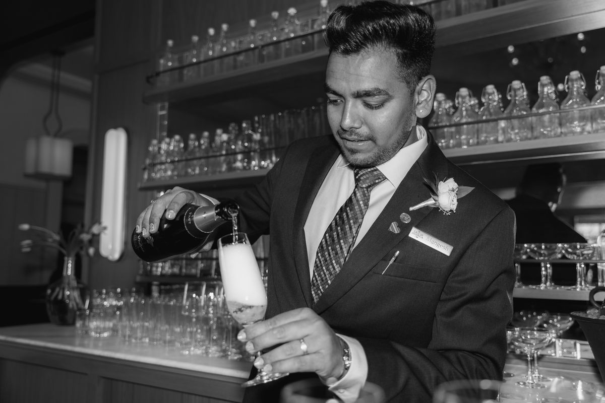 black and white photo of a man pouring a cocktail
