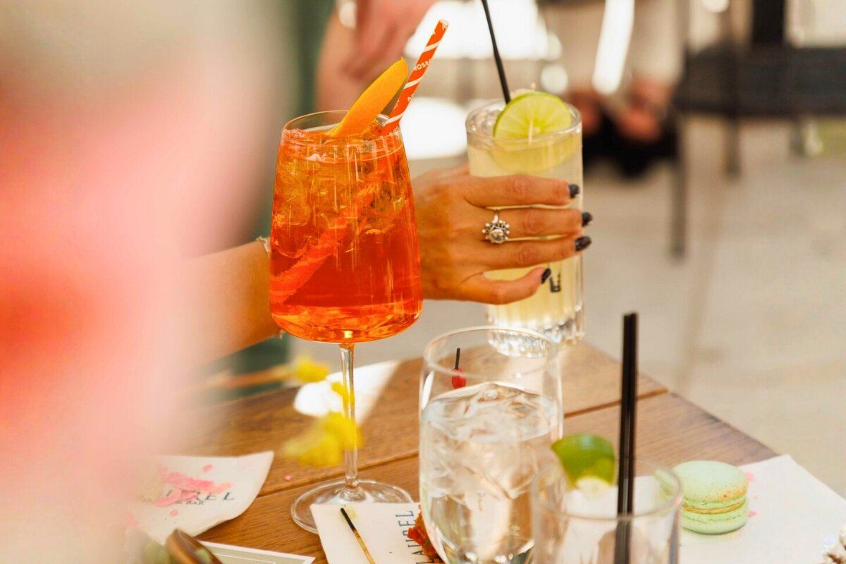 woman's hand grabbing a specialty cocktail from the bar