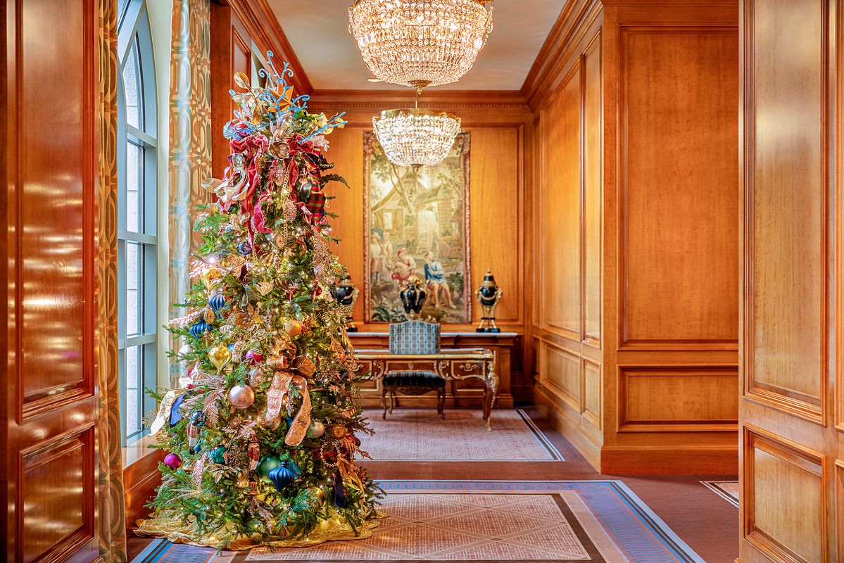 Christmas tree in front of a desk in a hotel hallway
