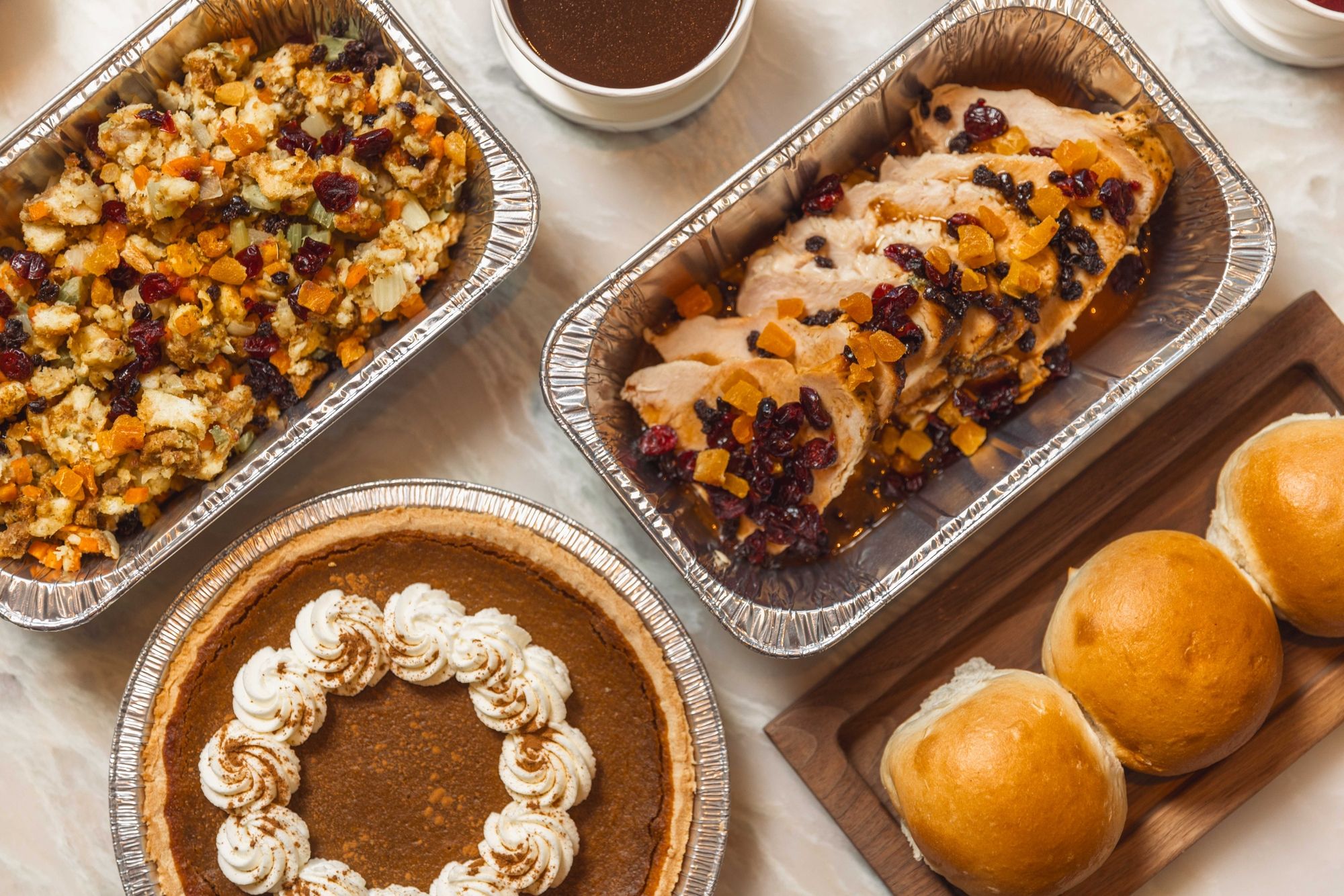thanksgiving dinner meal including rolls, turkey, pumpkin pie, and stuffing
