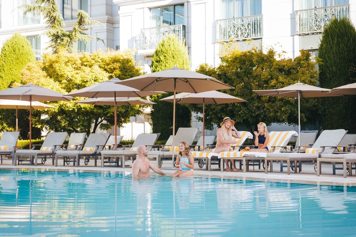 group of people hanging out by an outdoor pool