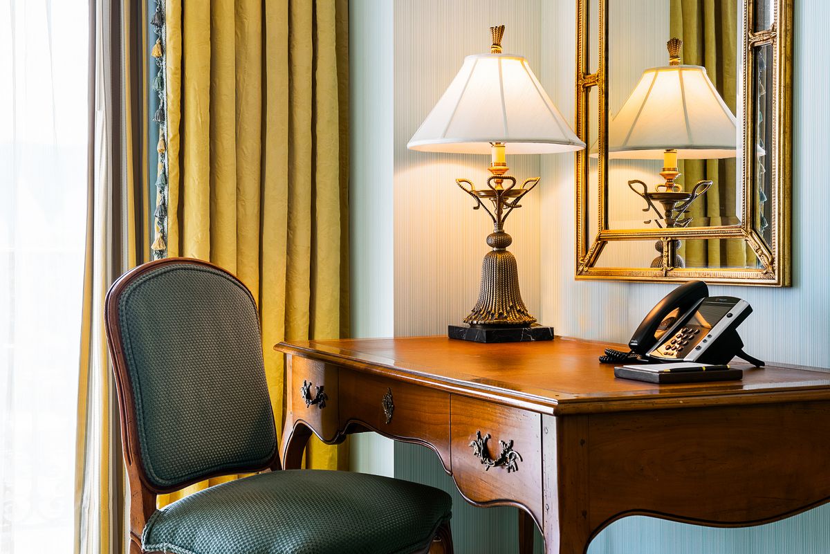 Desk with a lamp and phone alongside a chair