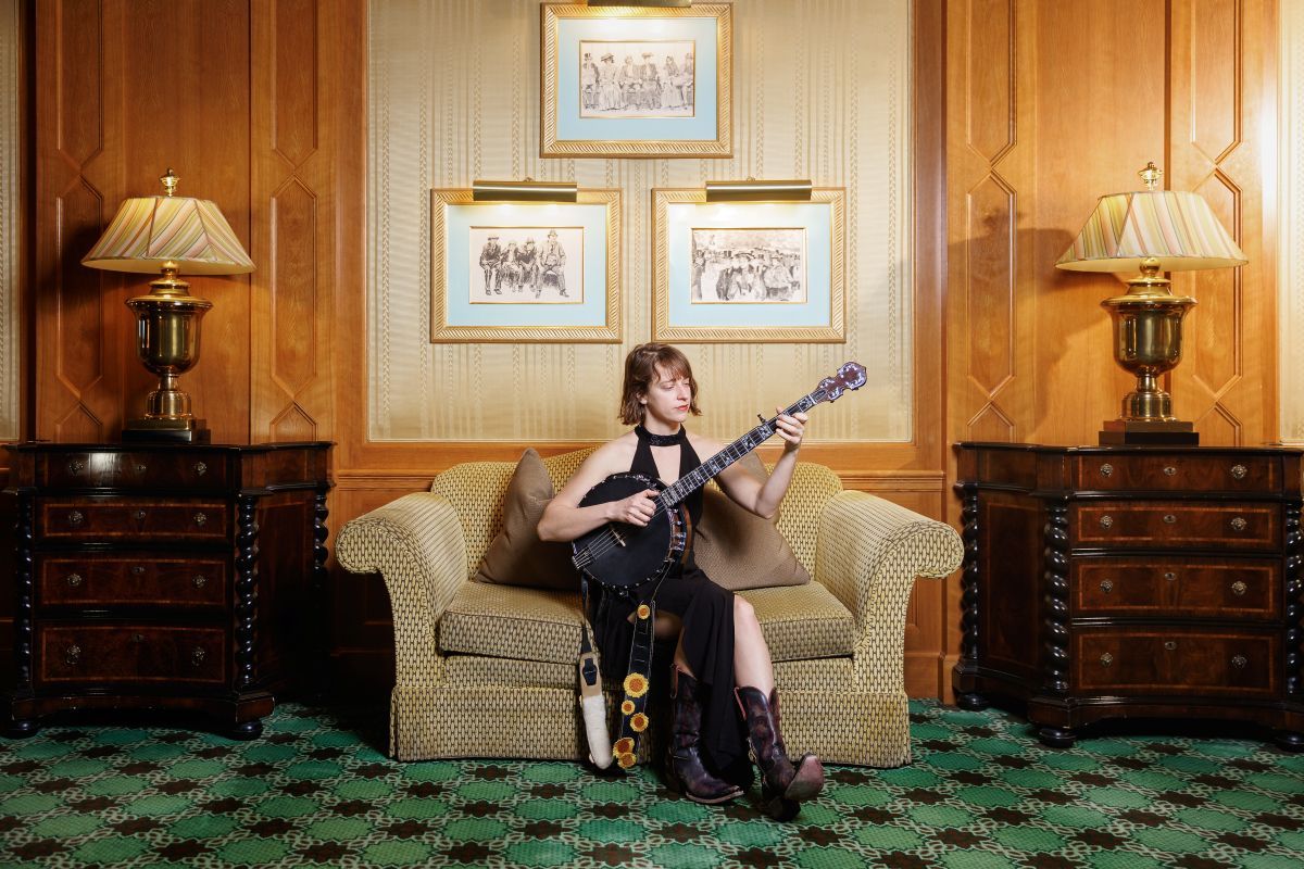 Woman playing a banjo on a couch
