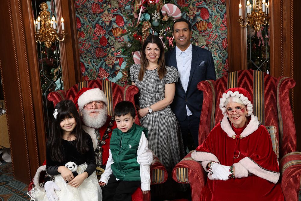 family posing with santa and mrs. clause