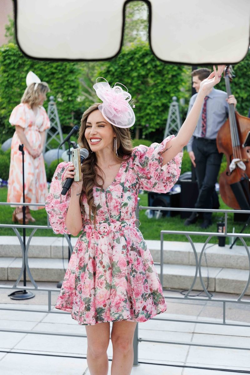 woman dressed in a pink floral dress and a hat for Derby Day