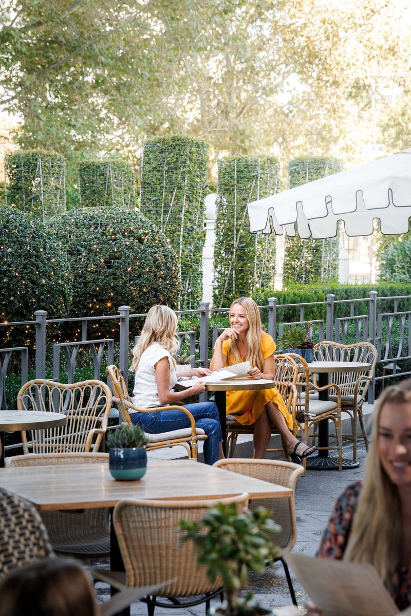 two women looking at menus on a patio