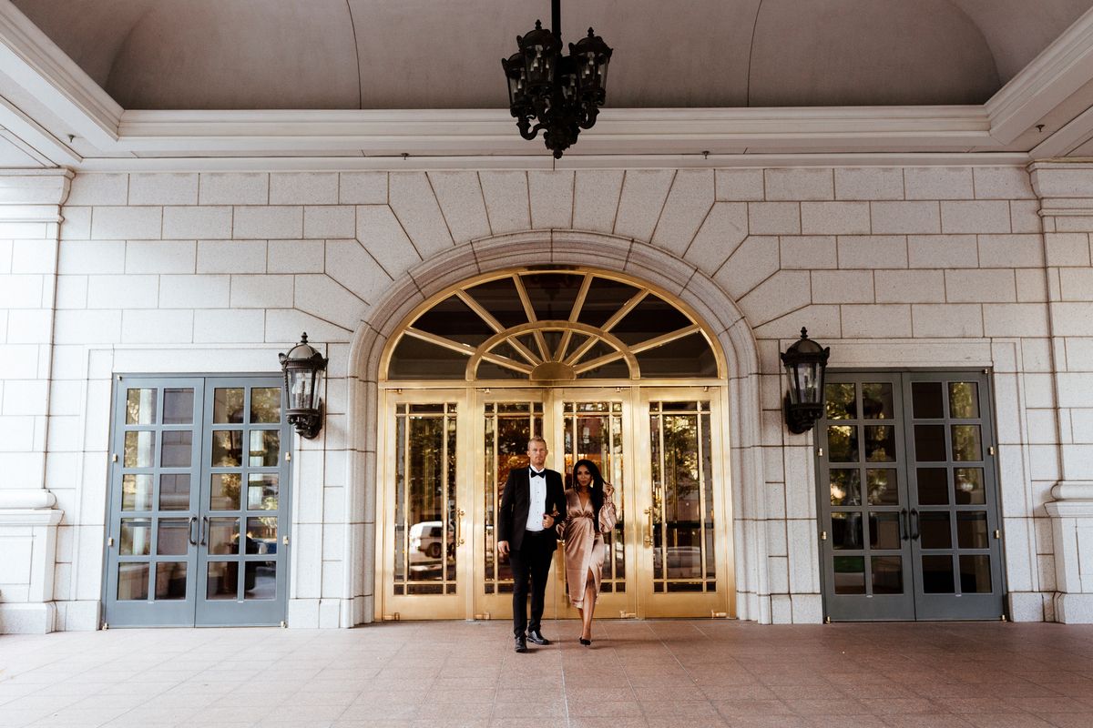 A couple standing in front of gold doors