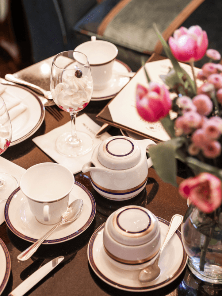 table set for tea with vase of tulips