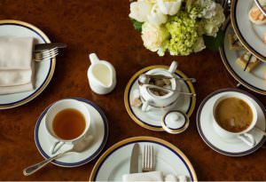 Table with a cup of tea and house-made finger sandwiches and dessert