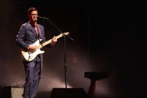 man playing guitar on stage