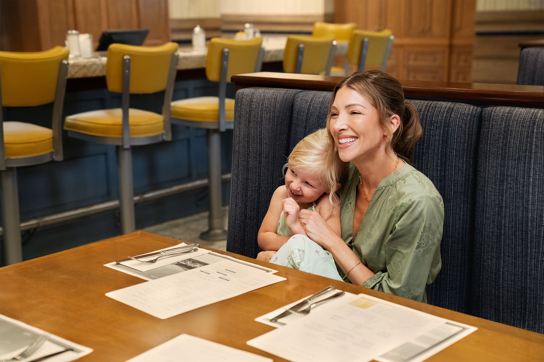 table with a plate of chocolate cake, another plate of salmon and vegetables, and two glasses of champagne