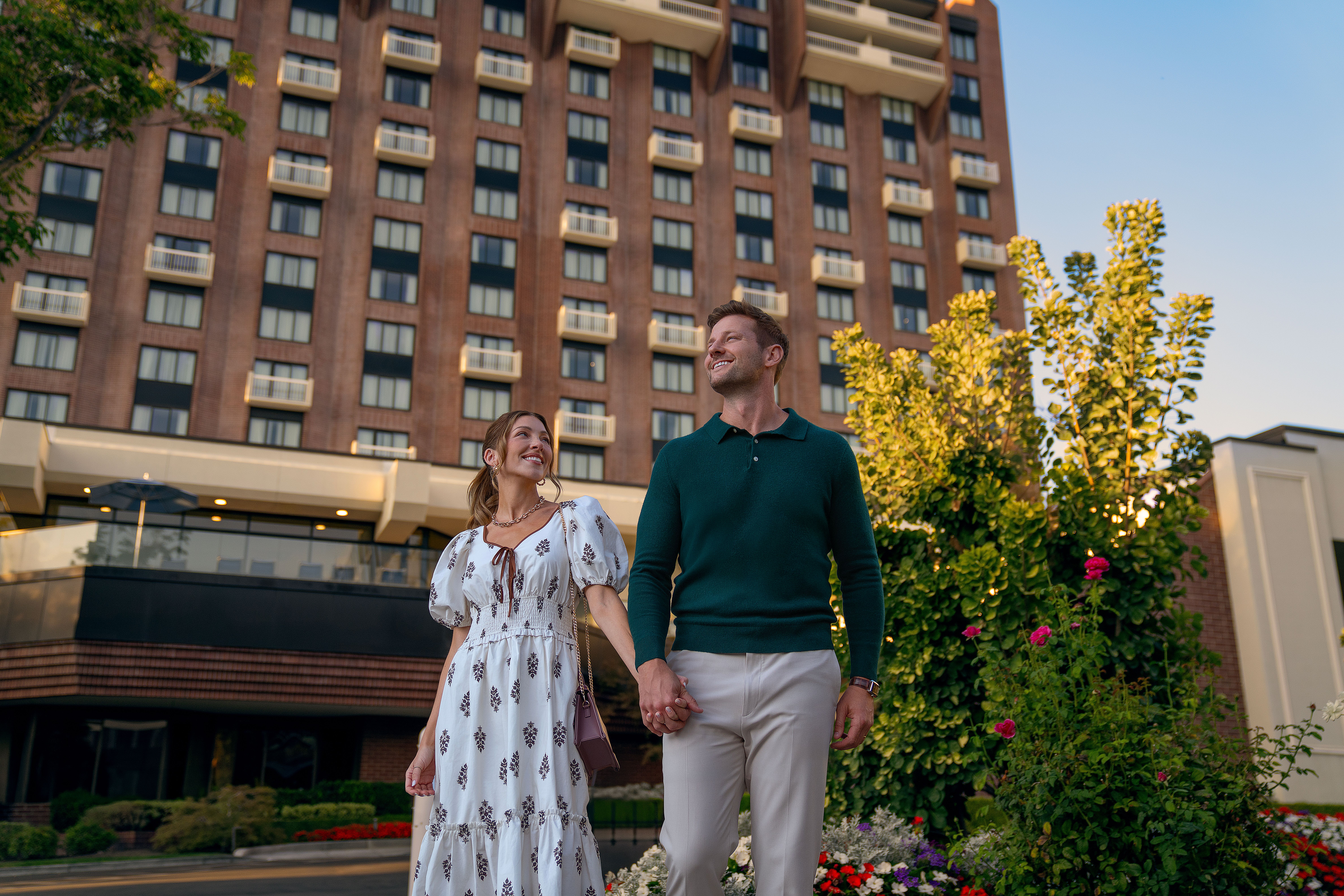 Couple holding hands outside of Little America Hotel