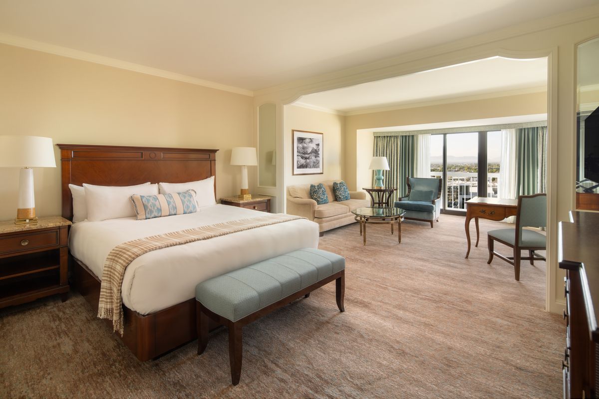 king bed in a hotel room with a living room area