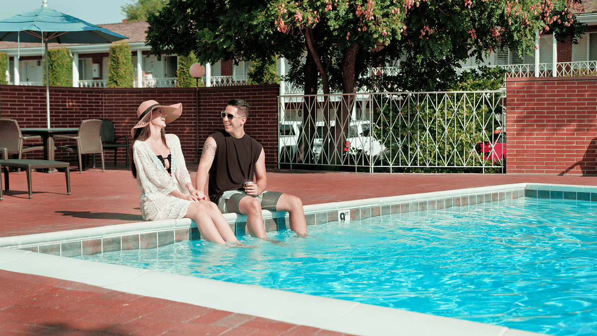 couple sitting on the edge of the outdoor pool at Little America Hotel in Salt Lake City