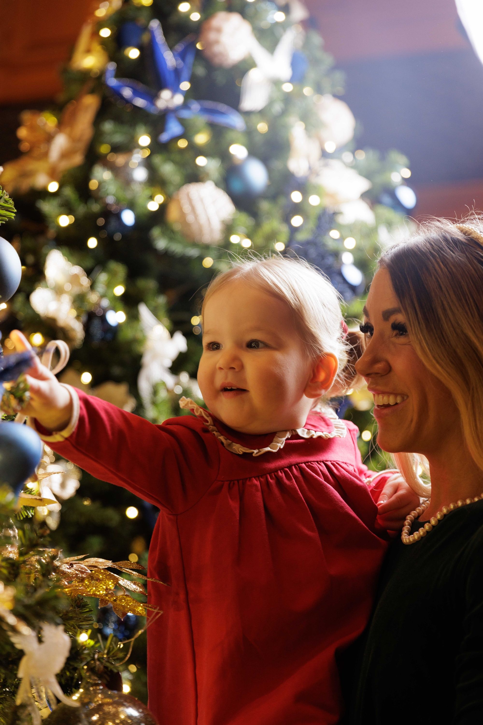 mother and daughter looking at a christmas tree