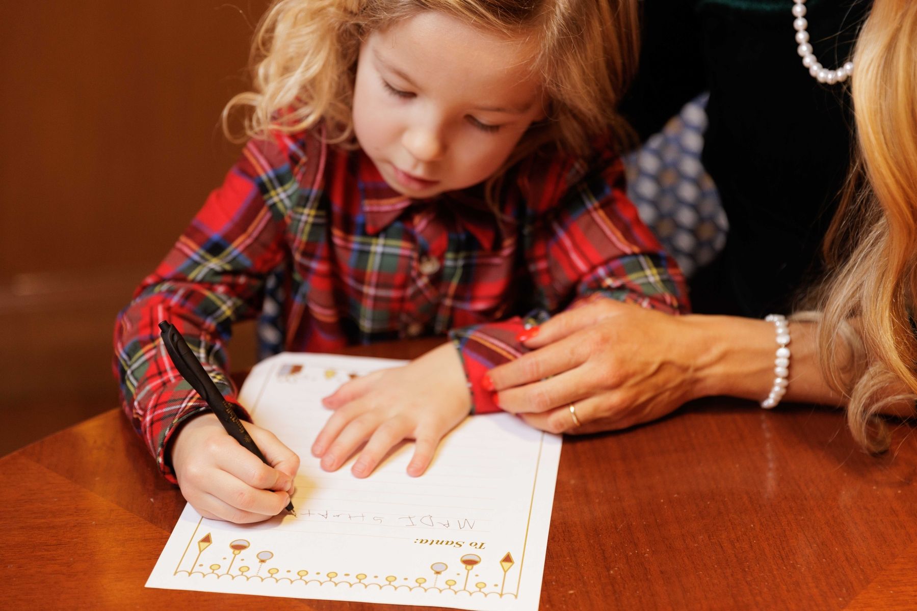 Mother and daughter writing letter to Santa
