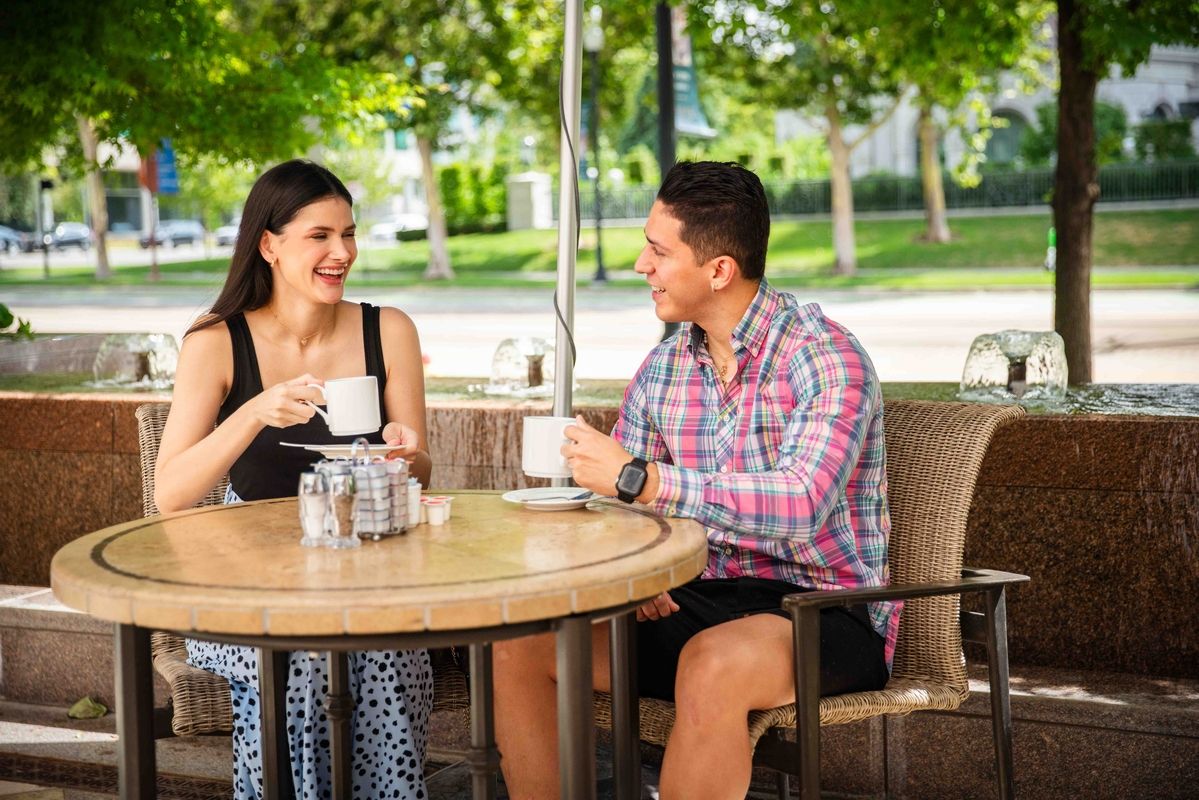 a couple drinking coffee on the outdoor patio of The Coffee Shop at the Little America Hotel in Salt Lake City